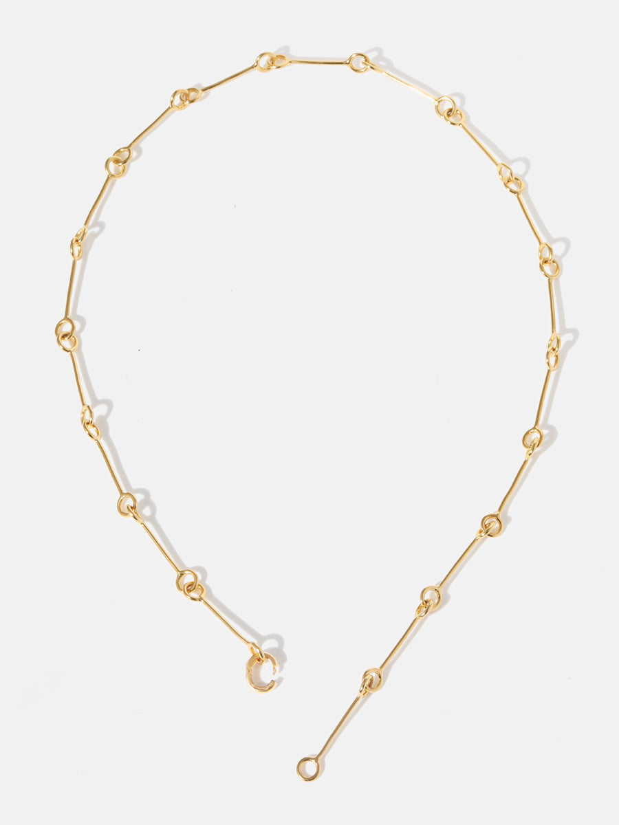 A gold 18 inch link chain necklace undone at the bottom with the clicker connector open to illustrate how it connects
