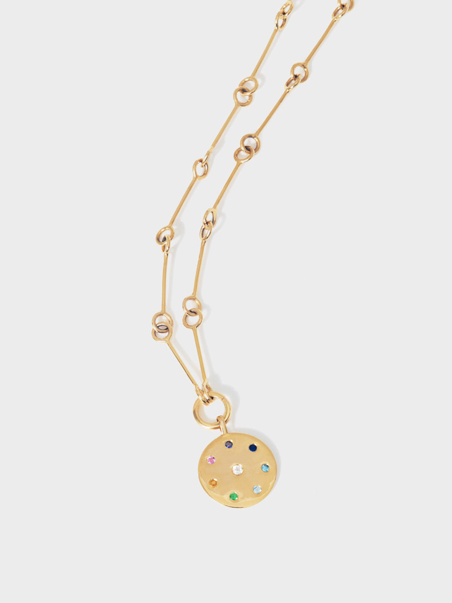 Close up of a gold 26 inch link chain with a gold multi gemstone pendant with 8 different coloured stones set in a circle and one centrally