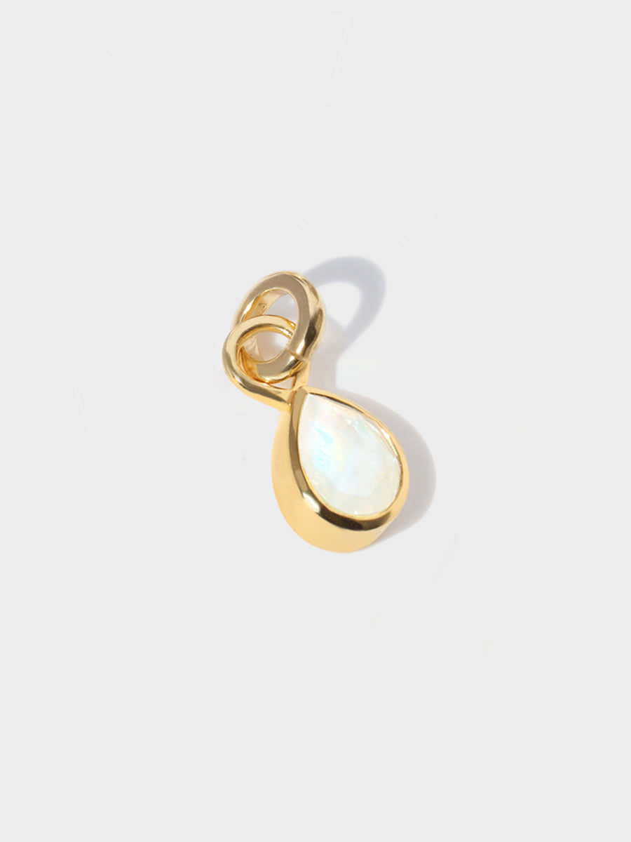 A large moonstone teardrop shaped charm set in a gold casing with large connection hoop at the top and clicker connector attahced. Grey background with shadow