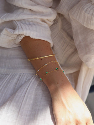Armbånd med vedhæng i form af en kugle af guldmalakit