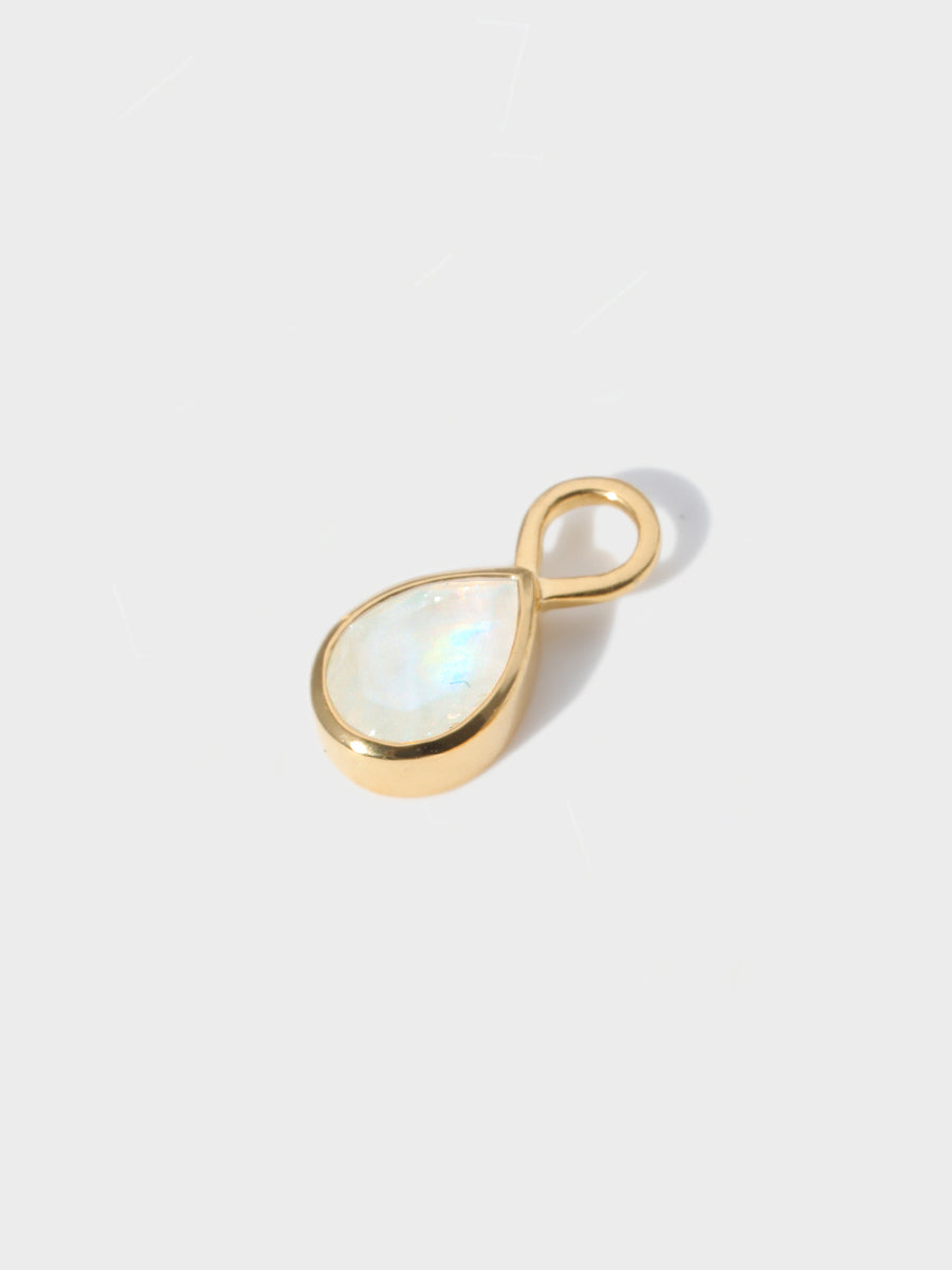 A large moonstone teardrop shaped charm set in a gold casing with large connection hoop at the top. Grey background with shadow
