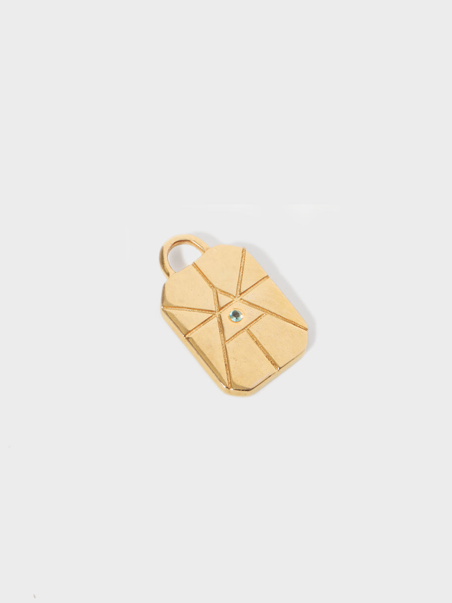 A gold air element rectangular charm with chamfered corners and a central blue topaz and large connection hoop at the top. Grey background with shadow