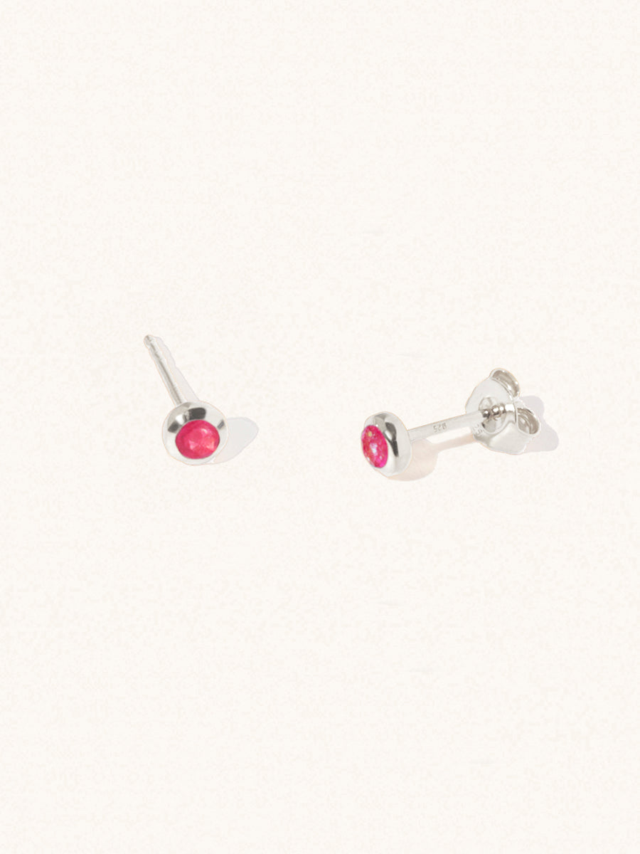 A pair of sterling silver small stud earrings with a 3mm ruby quartz gemstone in a 4mm setting and butterfly fastening. Set on a cream background with gentle shadowing.