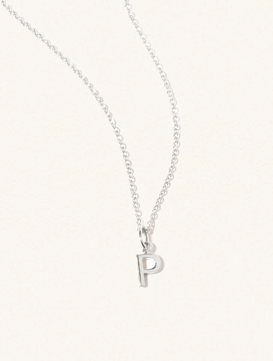 A sterling silver chain necklace with the caplital letter P approximately 8mm x 6mm. Set on a cream background with gentle shadowing.