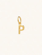 A gold caplital letter P approximately 8mm x 6mm with a connecting ring to thread through a necklace at the top. Set on a cream background.