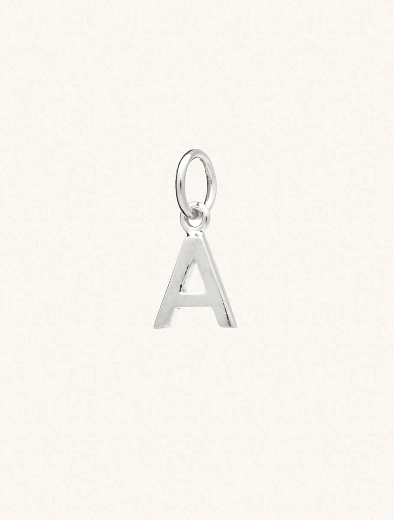 A sterling silver caplital letter A approximately 8mm x 6mm with a connecting ring to thread through a necklace at the top. Set on a cream background.