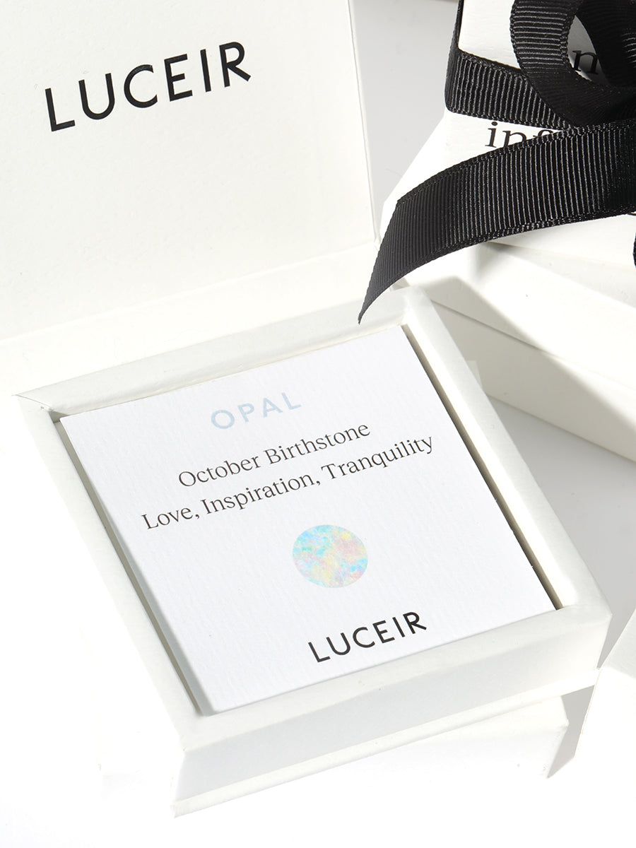 Luceir white packaging card set in a box saying Opal, October Birthstone, Love, Inspiration, Tranquility followed by a silver iridescent dot symbol underneath with Luceir logo at the bottom